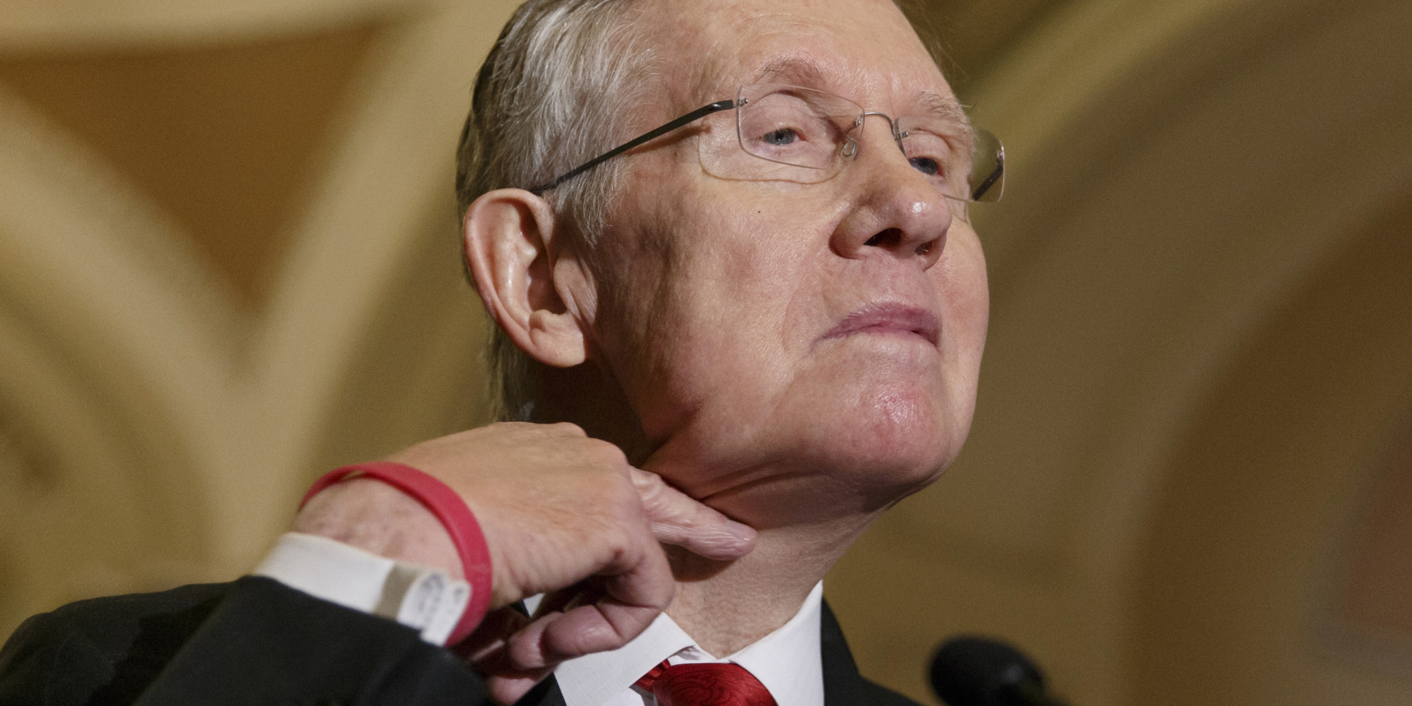 Senate Majority Leader Harry Reid of Nev. makes a cutting gesture across his neck, referencing House Oversight Committee Chairman Rep. Darrell Issa, R-Calif., who caused an uproar last week when he made the same gesture to order microphones cut as the top Democrat on his panel was trying to speak about the Internal Revenue Service scandal over targeting of conservative political groups,  Tuesday, March 11, 2014, during a news conference on Capitol Hill in Washington, Tuesday, March 11, 2014. Reid said that he thought the accusations of IRS misdeeds deserved answers. (AP Photo/J. Scott Applewhite)
